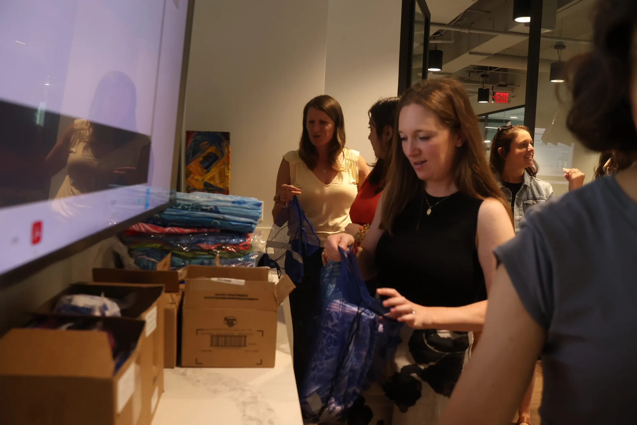 Jewish Federation of Greater Atlanta staff members pack blue welcome bags with camp supplies for Israeli teens participating in the Campers2Gether program.