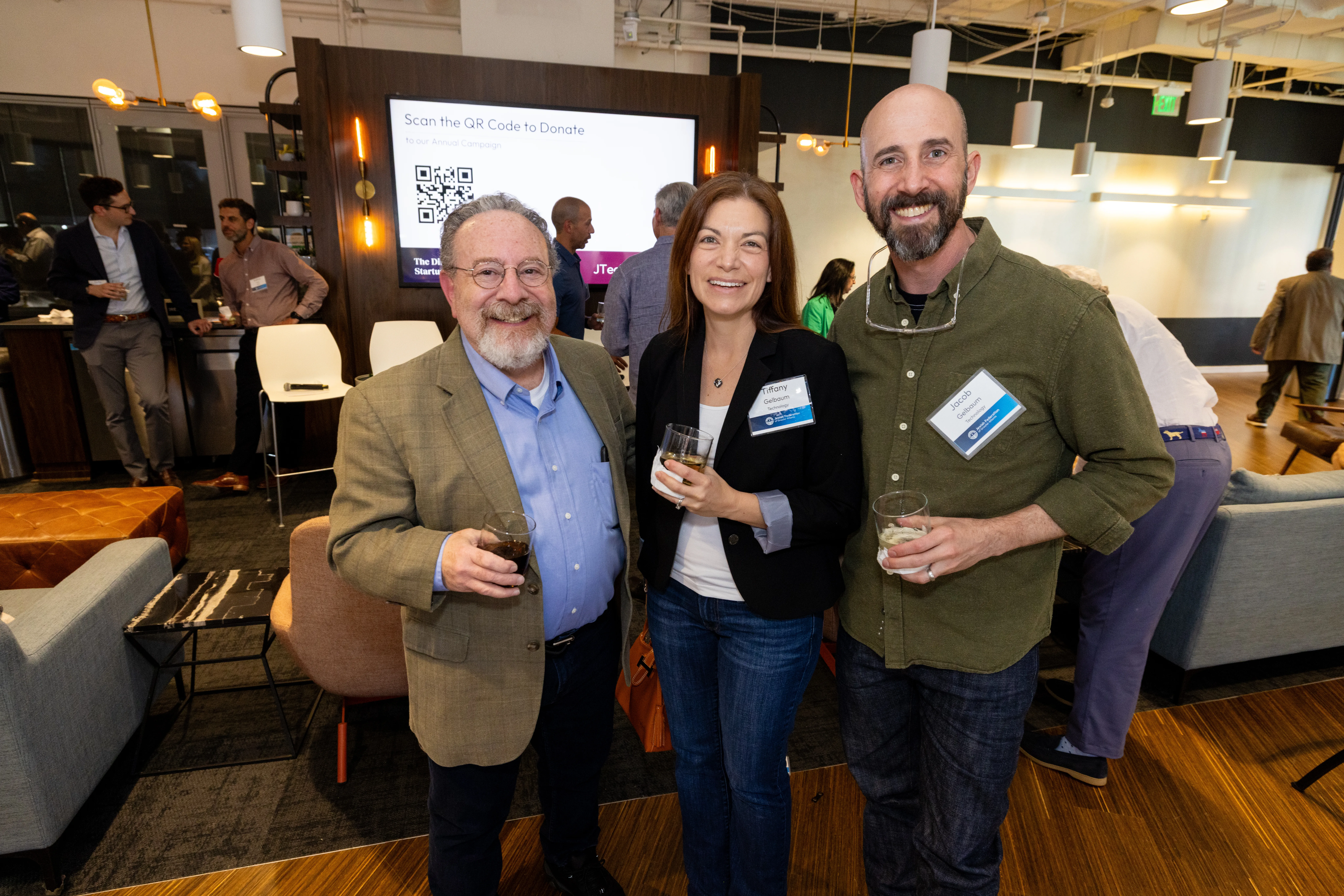 Three JTech event attendees smiling together at a networking event