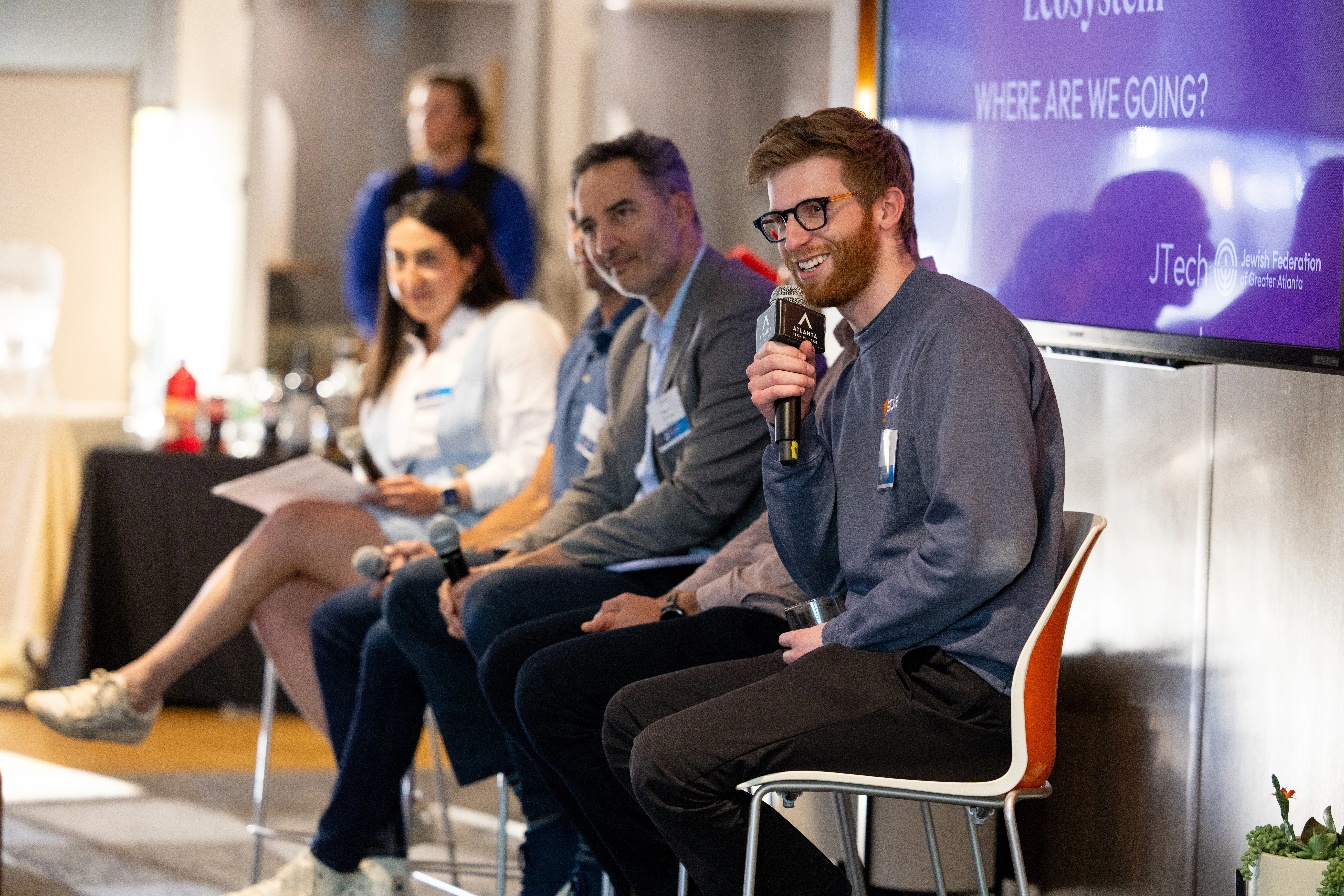 JTech panelist speaking into a microphone during a technology event