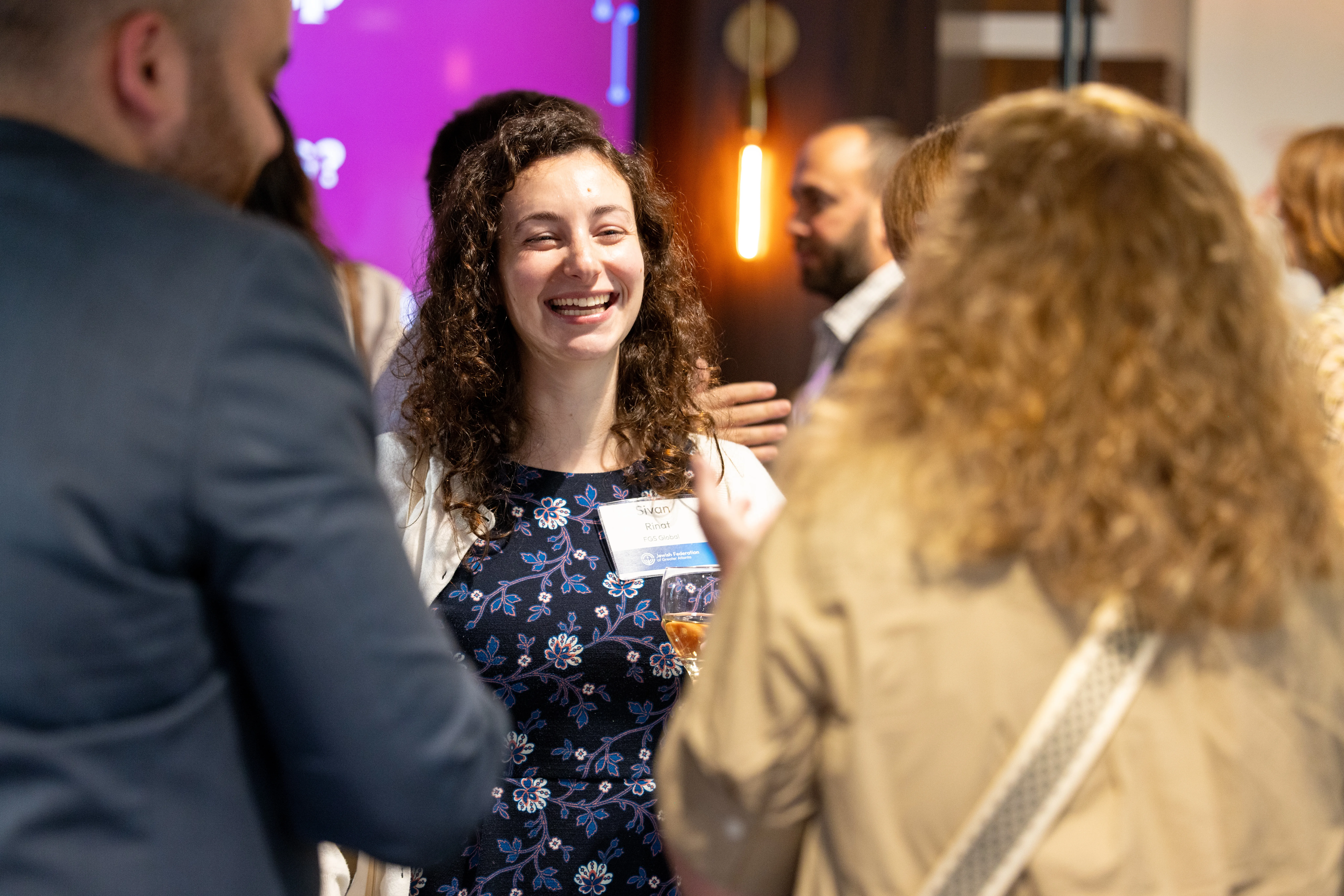 JTech event attendee smiling while talking with other guests at a networking event