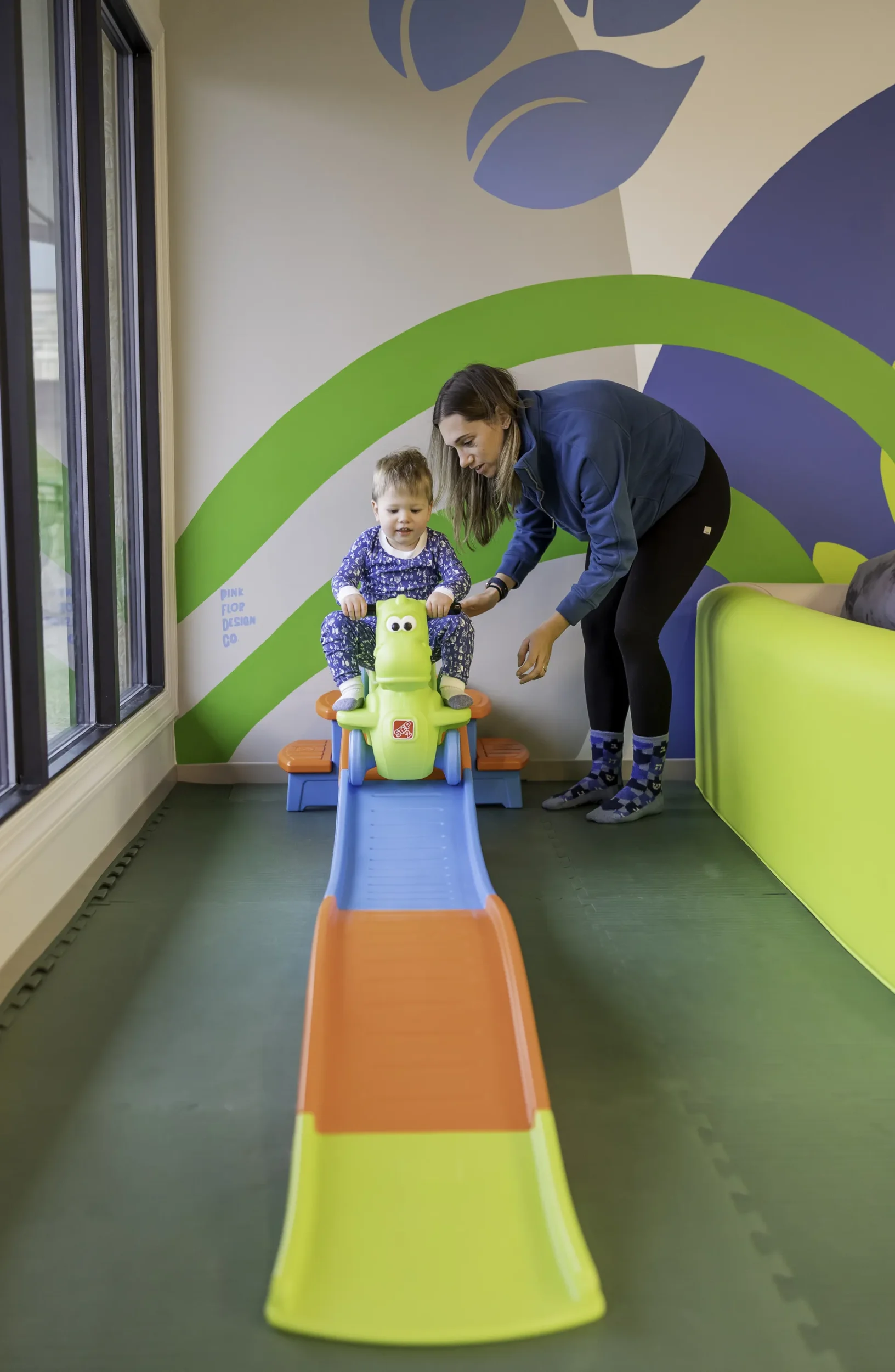 Mom pushes child on wheeled toy