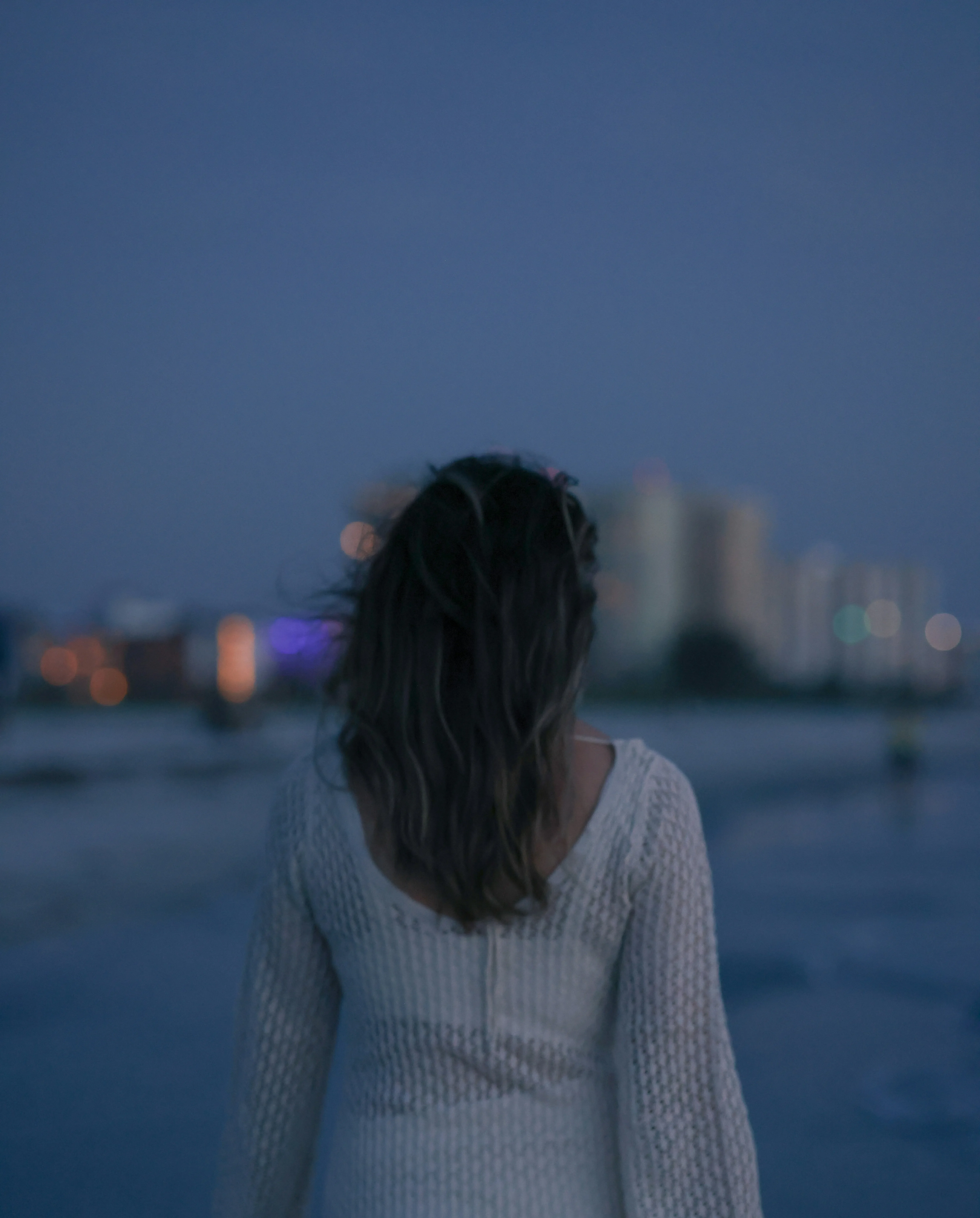 Woman walks on beach at night